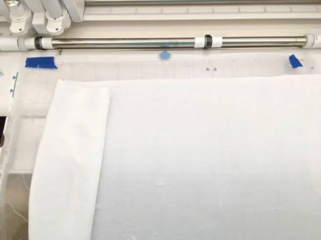 step 6 - SC - Position the shirt front on the cutting mat. If the size of your piece is wider than the cutting mat, vertically roll over the fabric not being sketched. If necessary, use painters tape to secure it and prevent it from interfering with the machine’s operation. Also position fabric so that overlapped layers do not feed under the rollers.