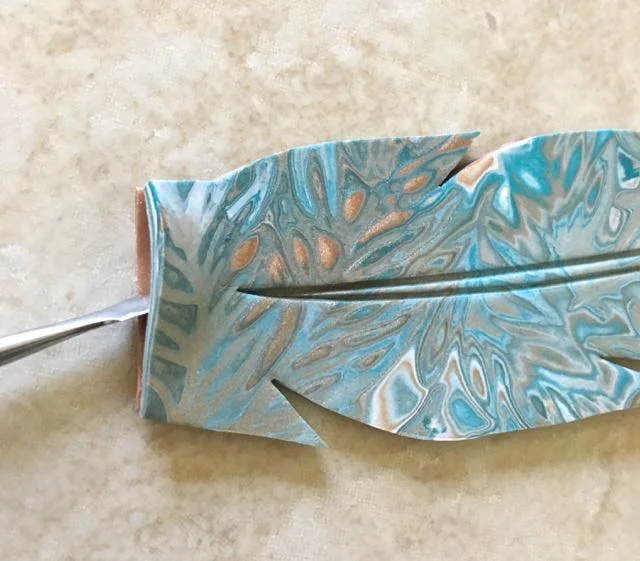 step 12 - With a blade tool, separate the layers on the straight edge of the feather. This is where the hinge will be inserted in step 20.