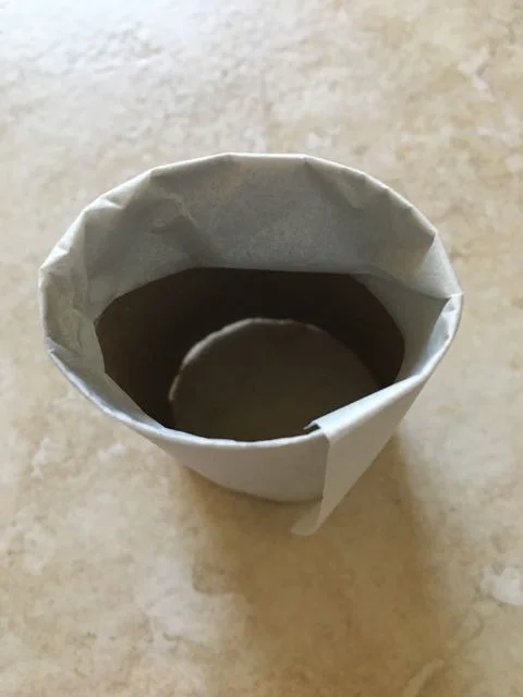 step 18 - Cut parchment paper to measure 5" wide. Wrap it around the roll and tuck the excess width inside to hold the parchment in place.