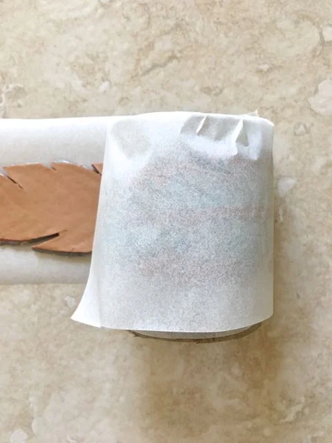 step 22 - Using the parchment paper, wrap one feather over the form. Wrap the other feather over the first being sure there is paper between the clay pieces so they don't bond while baking.