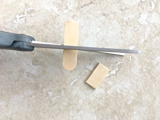 step 1 - Cut two one-inch pieces from a craft stick. These "connectors" will hold the three sled craft sticks together.
