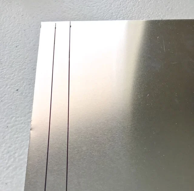 step 8 - With a marker, draw a line 3/8" from the edge of the metal sheet. Draw another line at .75".
