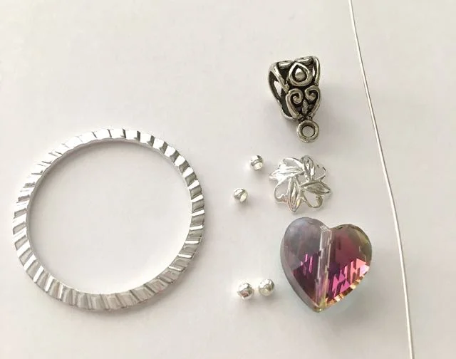 All you need - C rystal heart bead, round silver beads, bead cap, wire, bail, and sculpted silver ring