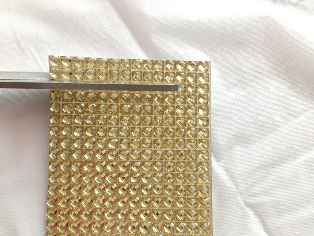 step 4 - Cut the gold rhinestone sheets into four, 3" x 1" strips. Adhere them to the top of the glass container.
