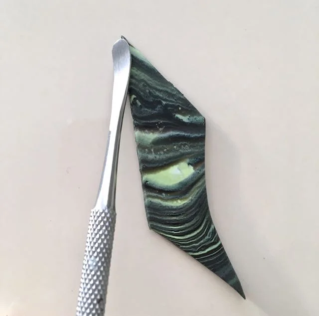 step 10 - With a sculpting tool or the back of a small spoon, smooth and bevel the bead edges.