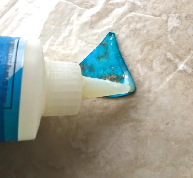 step 5 - Place the two beads on a protected surface. Apply a thin line of Diamond Glaze on the perimeter of each bead. Dot more in the center. The glaze will mound slightly and fill in the empty center space. Allow the beads to dry.