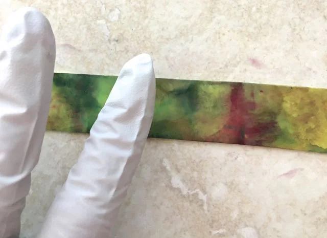 step 4 - You can also control color placement by spraying alcohol on the tile, touching your gloved finger to it, then rubbing across the clay to blend colors. Dab at the clay with more color from the tile to create the mix you like. 