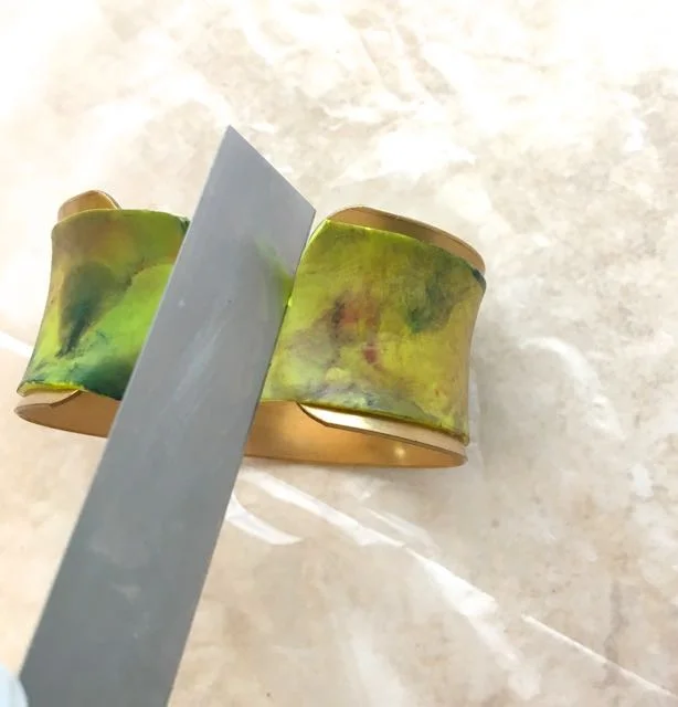step 8 - Using a blade, push against the edge of the metal form to cut away excess clay.