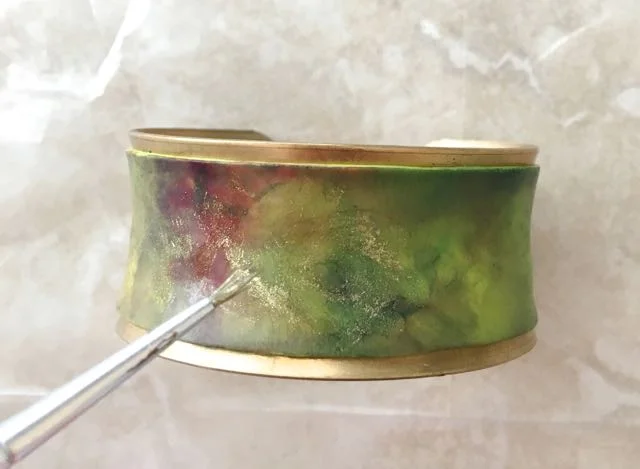 step 10 - Using a fine brush, apply gold ink in an irregular pattern. If the lines of the ink are too defined, dip the brush in pure alcohol, blot slightly and blend the ink edges with the brush to diffuse the lines. Use a light touch when applying the metallic ink so you don't dilute the underlying colors.