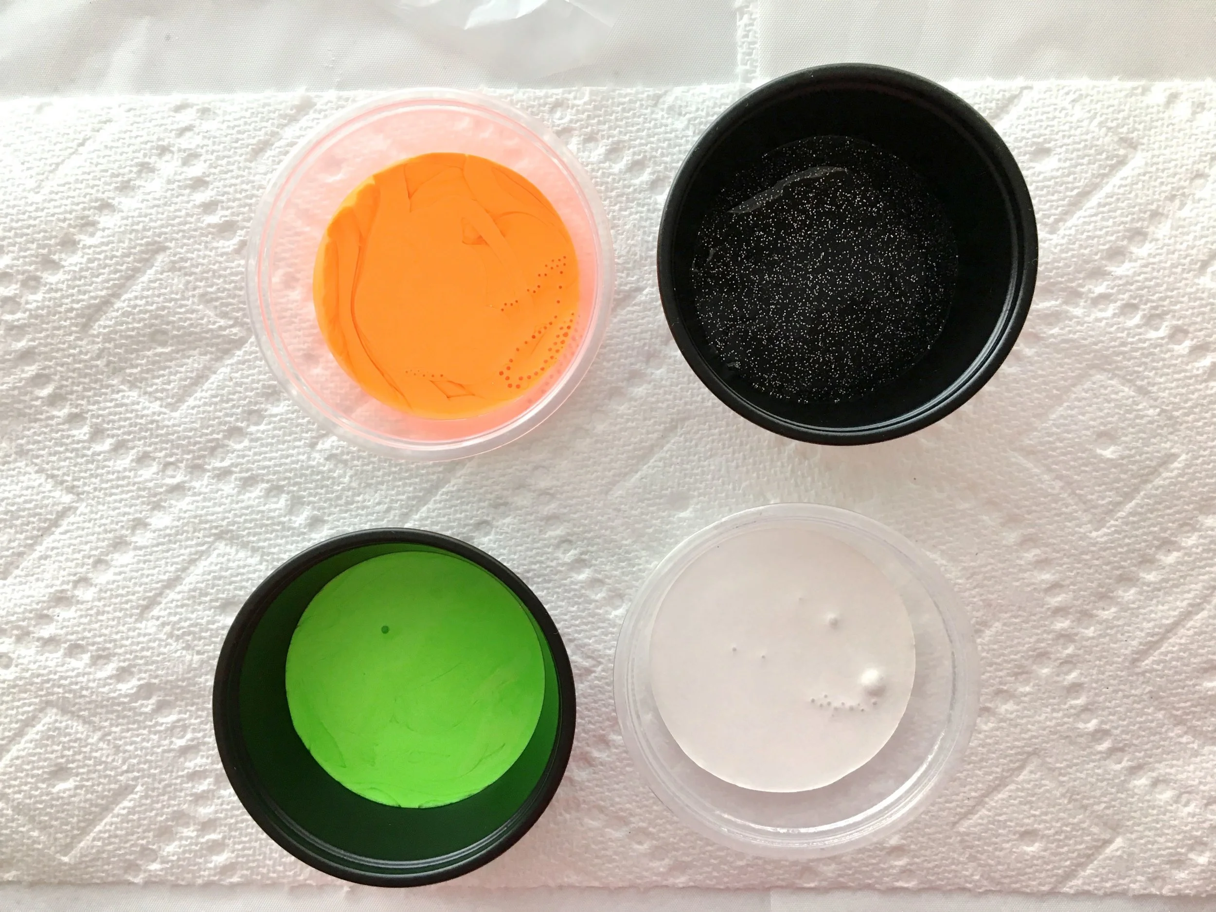 step 2 - Pour approximately one ounce of each paint color into small disposable plastic containers – Orange, Black Ice, Alien Green, and White. Pour about two ounces of Black paint for the base color in a separate container. Add Testors Marbling Medium to each container in a 50/50 ratio.