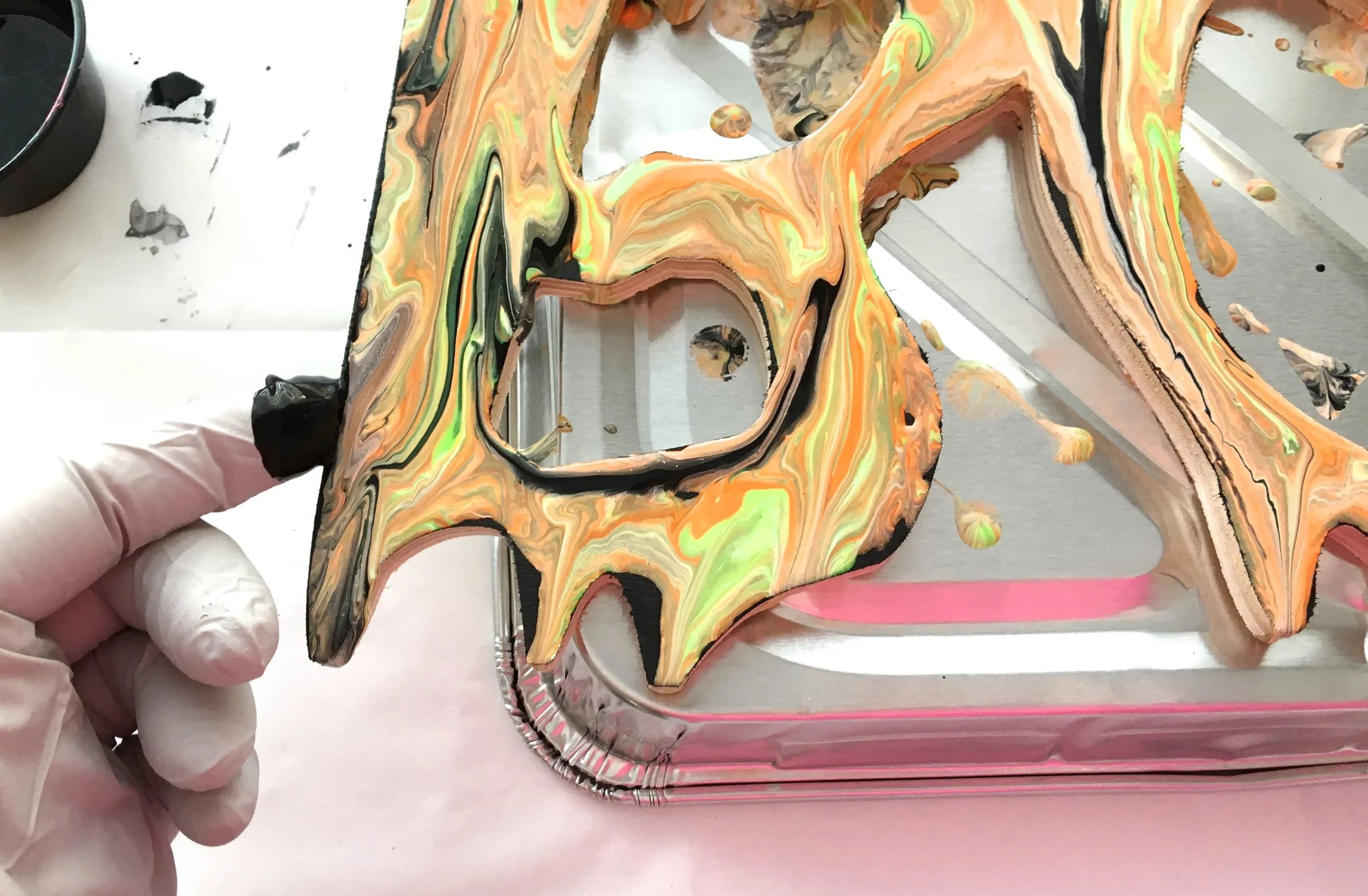 step 10 - With a gloved finger, paint the raw inner and outer edges of the plaque with paint that has dripped down the sides. Pick up more from the work surface as needed. Use any color. The plaque should not look perfectly outlined.