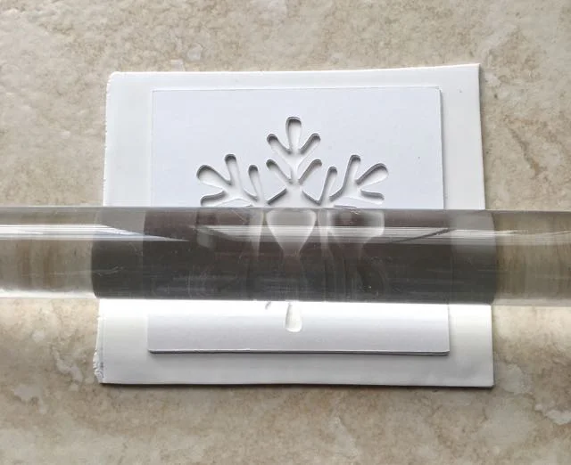 step 12 - Place the template on the clay powder side down and roll across it until the clay rises up to (but not above) the surface of the card stock. Remove the card stock.