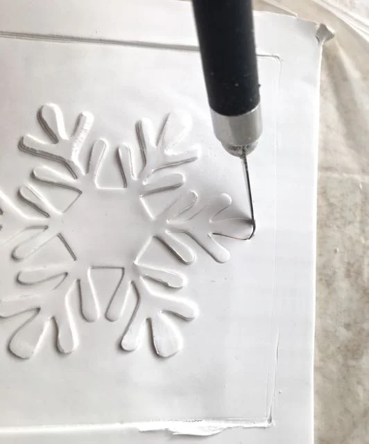 step 13 - Outline the impression with a sharp craft knife. Use the film to turn the clay as you work so you don’t have to lift the blade from the clay to change positions. Keeping the blade in the clay will result in a smoother cut.