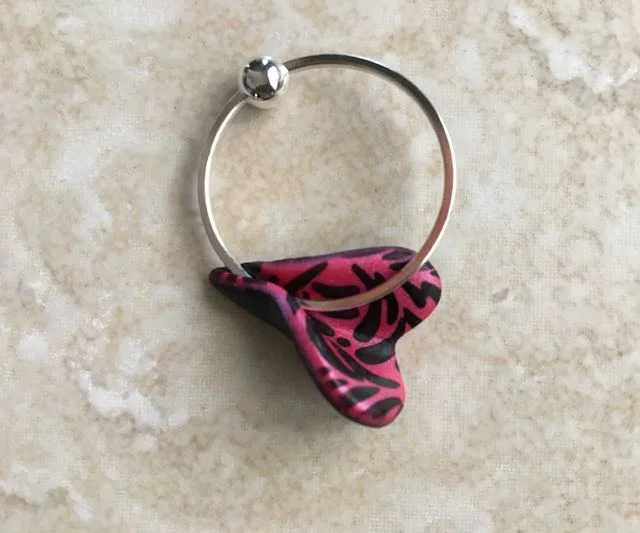 step 9 - Bring the outside edges of the heart bottom together to enclose the ring. Conceal the cut in the ring by positioning it inside the bottom of the heart. Add a bit of liquid polymer clay to the surface of the enclosure to bond it to the metal when baking.