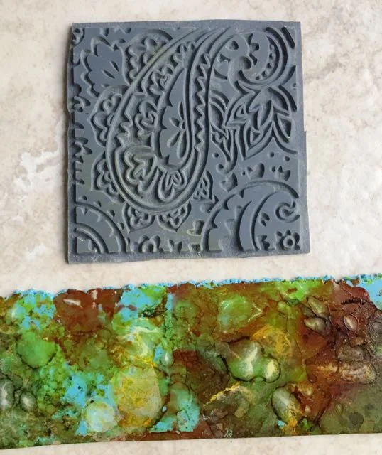 step 4 - Allow the ink to dry completely. Choose a rubber stamp to emboss the clay.