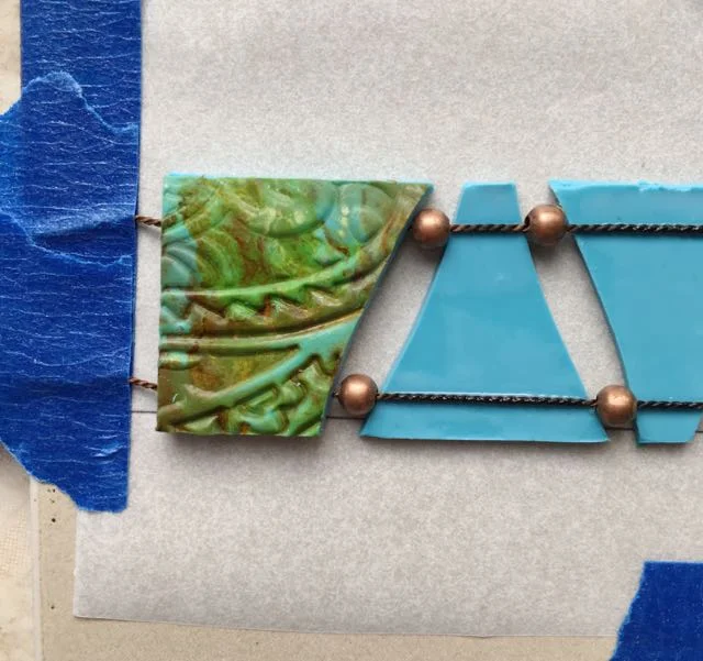 step 18 - One by one, brush the back sides of the embossed clay pieces and place them on the turquoise pieces aligning the edges.