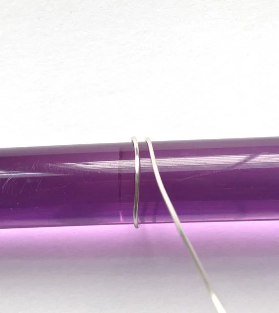 step 4 - Smooth 18 gauge wire around a cylinder to create a perfect circle. The cylinder should measure ¾” across. I used an acrylic clay roller.
