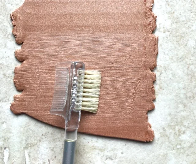 step 1 - Roll out a four-inch square of copper (or color of your choice) clay on the number two setting of the conditioning machine. Drag a stiff brush horizontally across the clay. I tried several brushes but most were too soft. I also tried a comb but the teeth were too far apart. I found a mascara brush was the perfect tool.