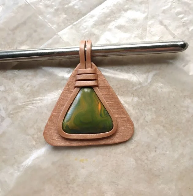 step 18 - Wrap the two long clay strips to the back of the pendant around a dowel.