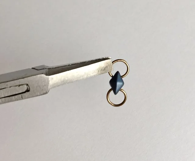 step 6 - Create one more ring (as in step 1 & 2) for each earring using the 20 gauge wire. Insert the new ring into the the bottom hole of the remaining bead/ring unit.
