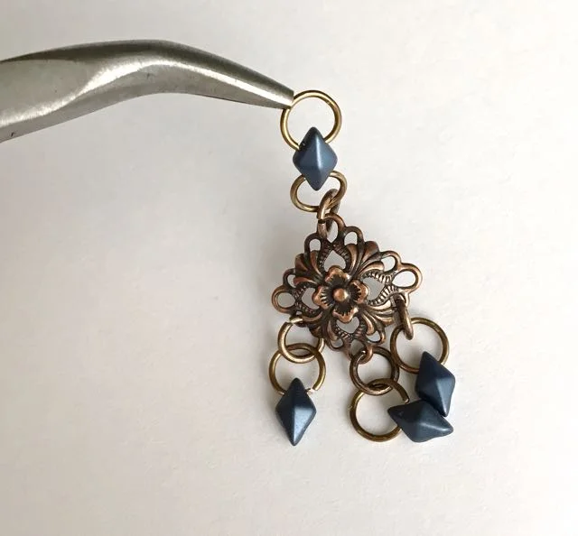 step 7 - Attach the double ring unit to the top hole of the filigree with a 6mm jump ring. Attach an earring wire to the top 6mm ring.