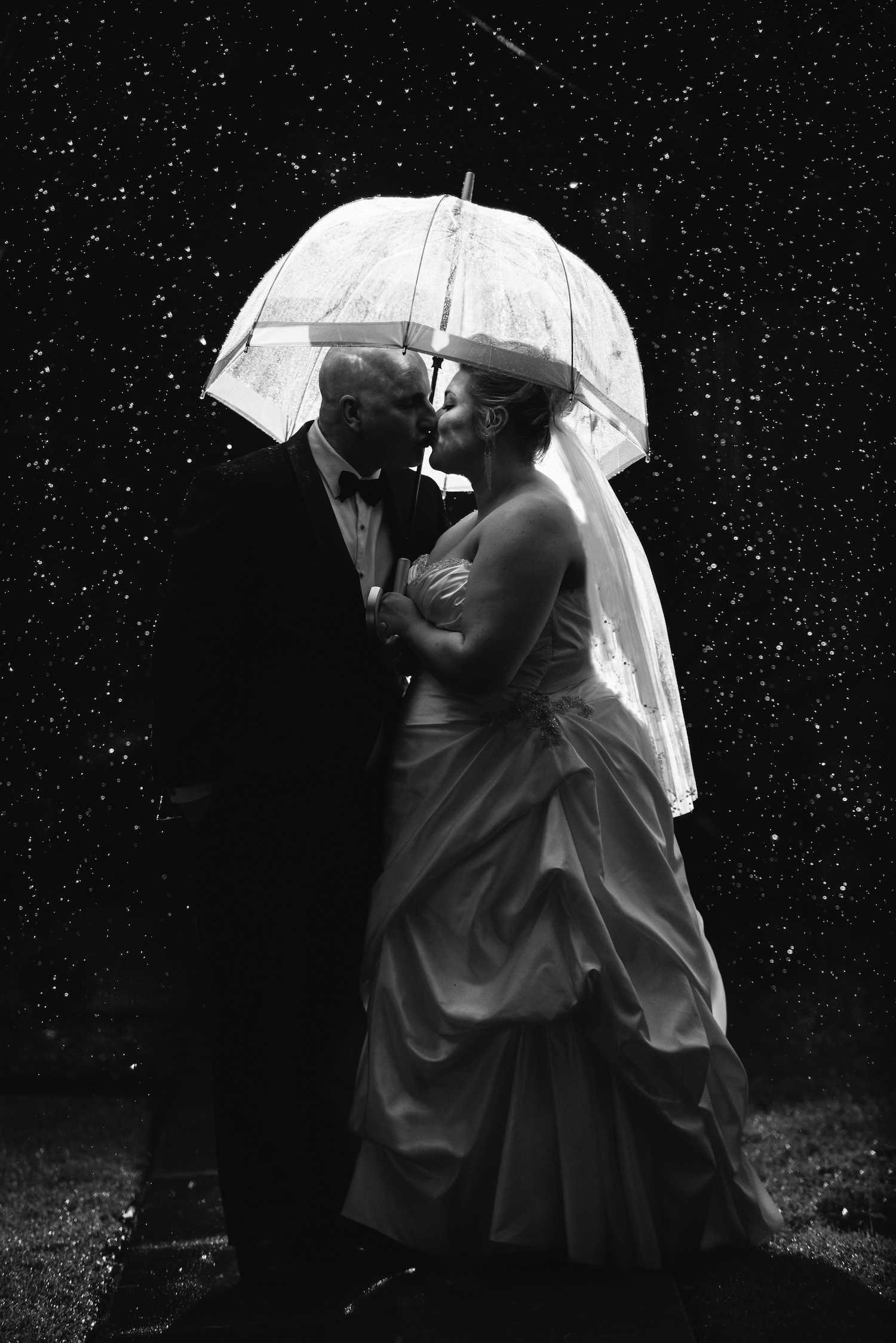 Rainy Wedding Day Night Portrait Bride Groom Kissing under umbrella Lightsmith Images Brisbane Wedding Photographer