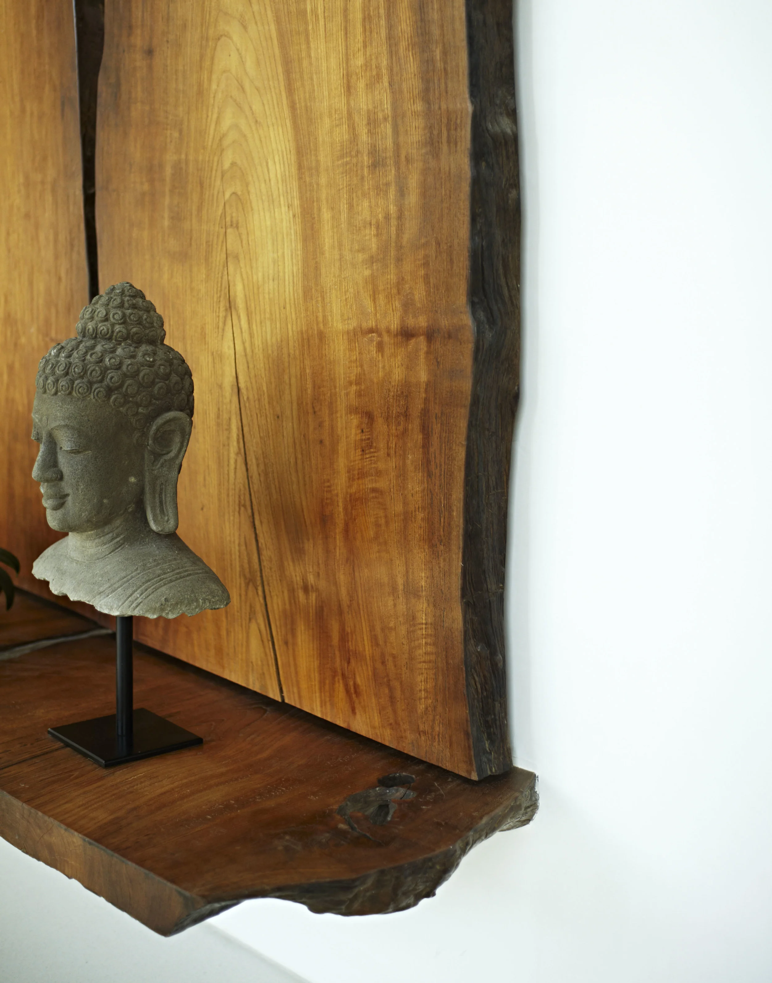 Buddha sculpture and wooden wall hanging and bench