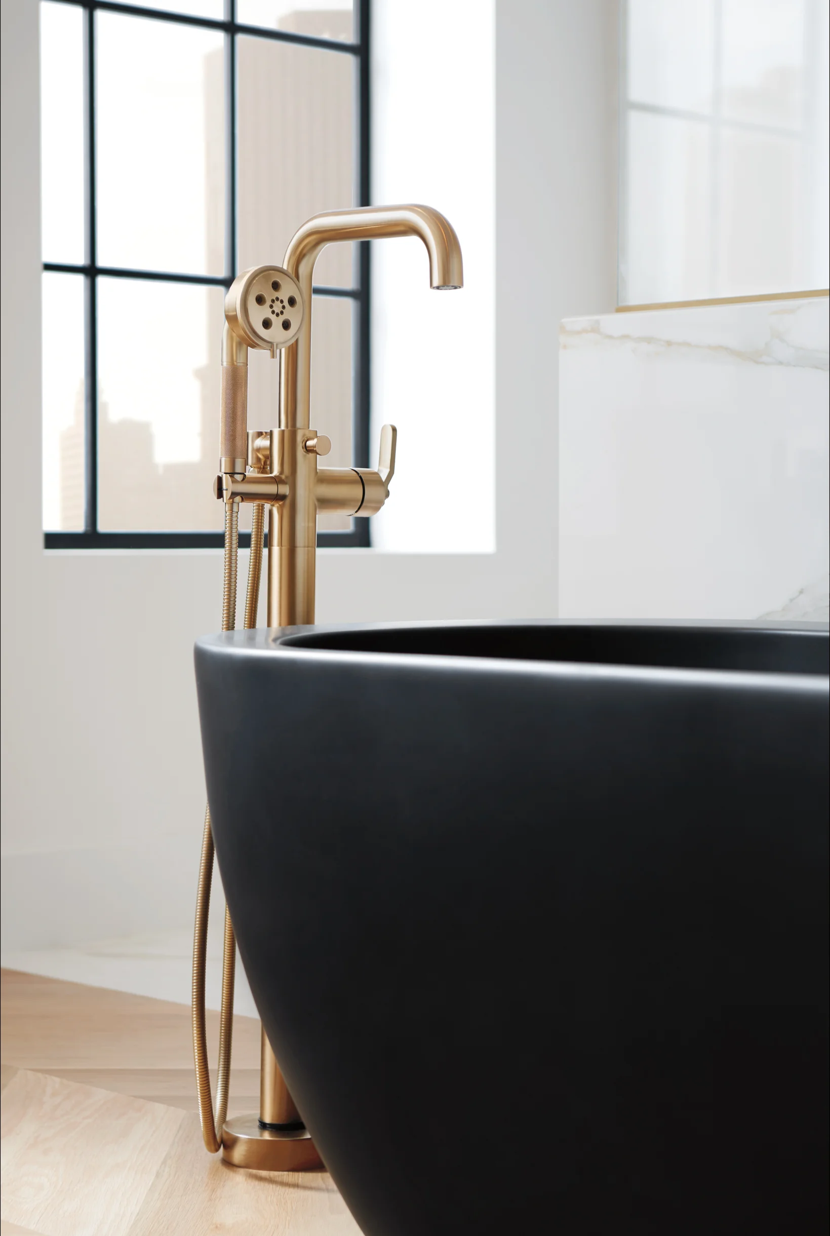 Brizo Litze collection minimal modern bathroom showroom interior with black tub and brass fixtures