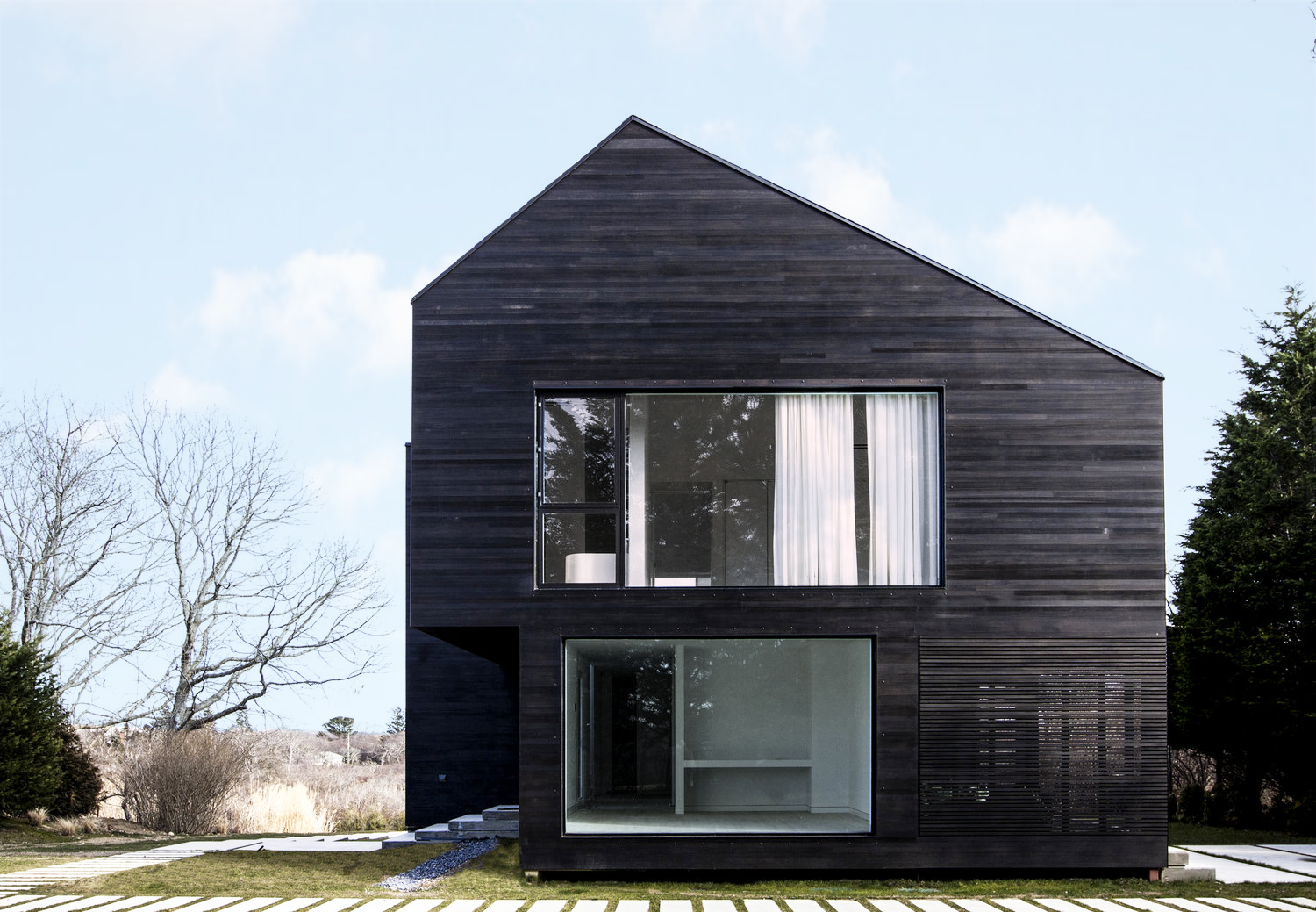 Black Modern barn house with Shou Sugi Ban cedar siding and windows