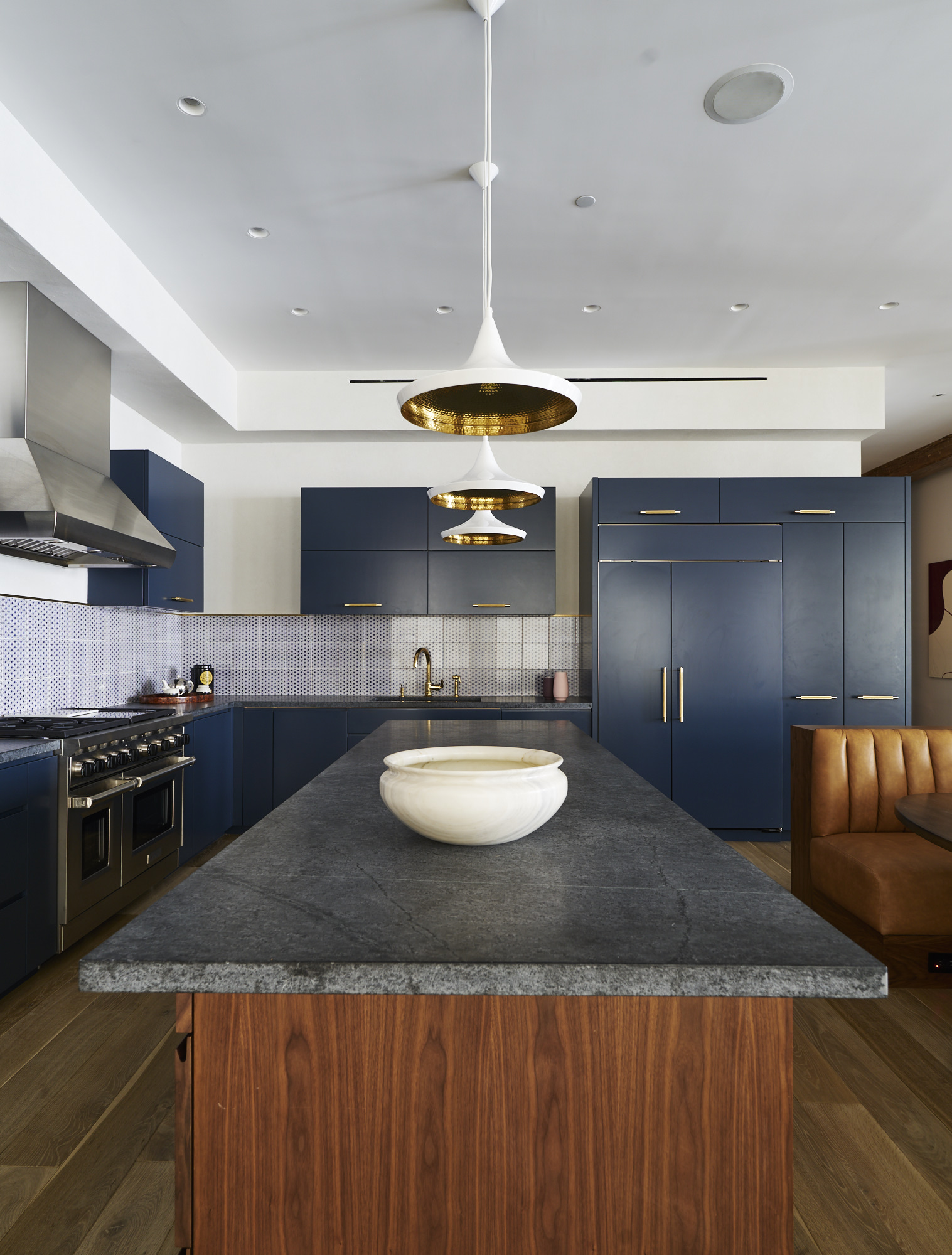 Modern Soho loft renovation blue kitchen with wooden island and brass fixtures
