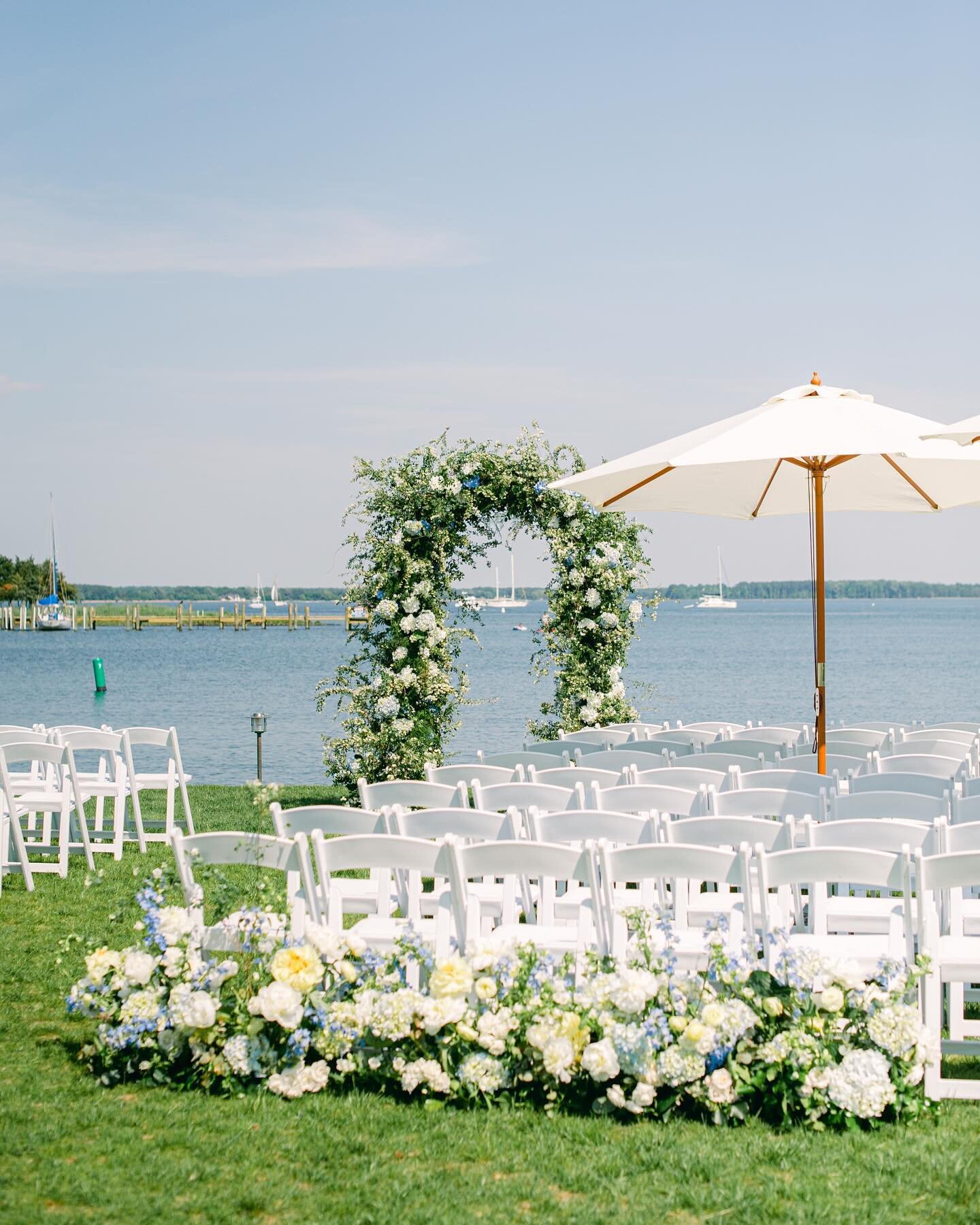 A breezy palette of dusty blues, greens and pops of sunny yellow for S&amp;P&rsquo;s ceremony on the Eastern Shore. A lush, textural floral arch by @sophiefelts created the perfect backdrop to frame the couple and those breathtaking water views! 

Ph