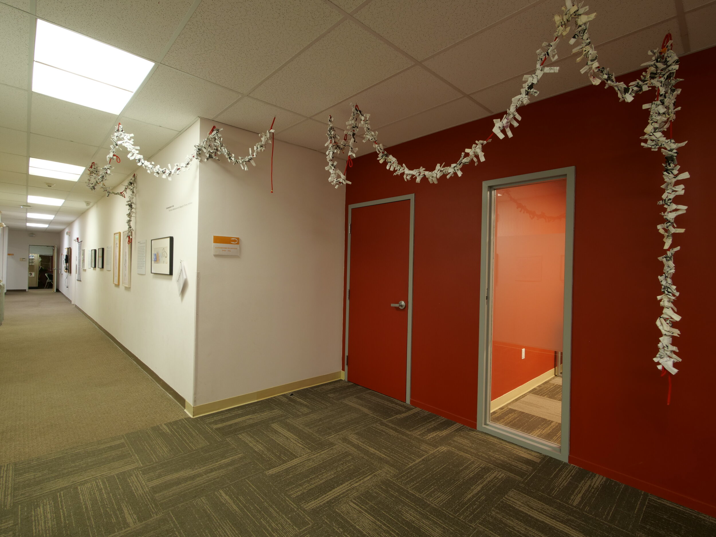 Hallway intersection draped in garlands of white material. 