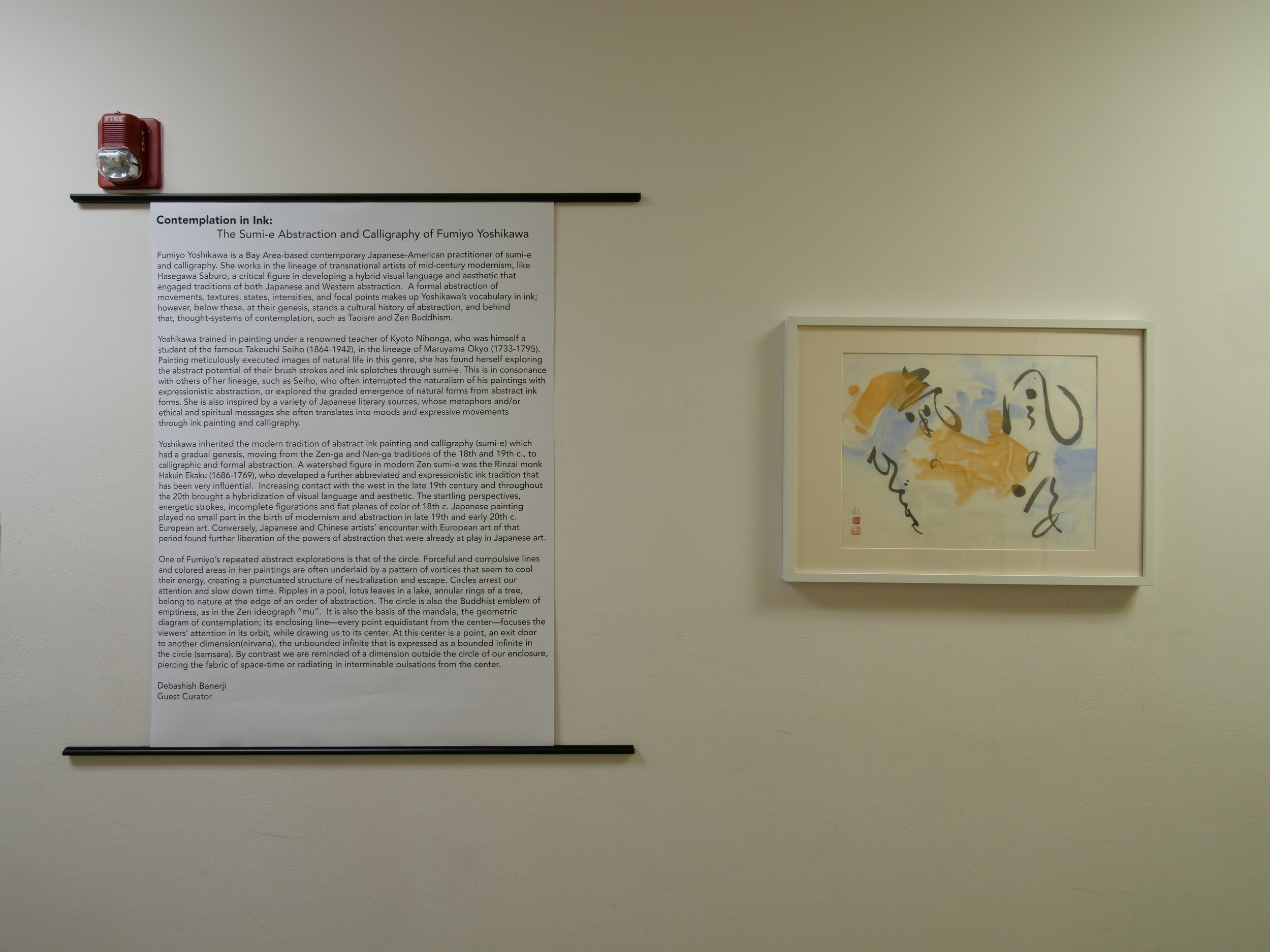 A panel describing the artist's work next to a colorful ink drawing.