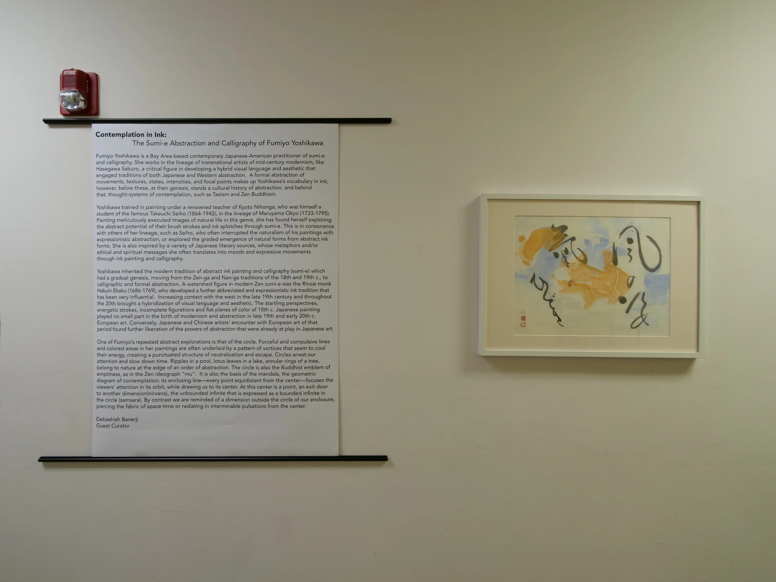 A panel describing the artist's work next to a colorful ink drawing.