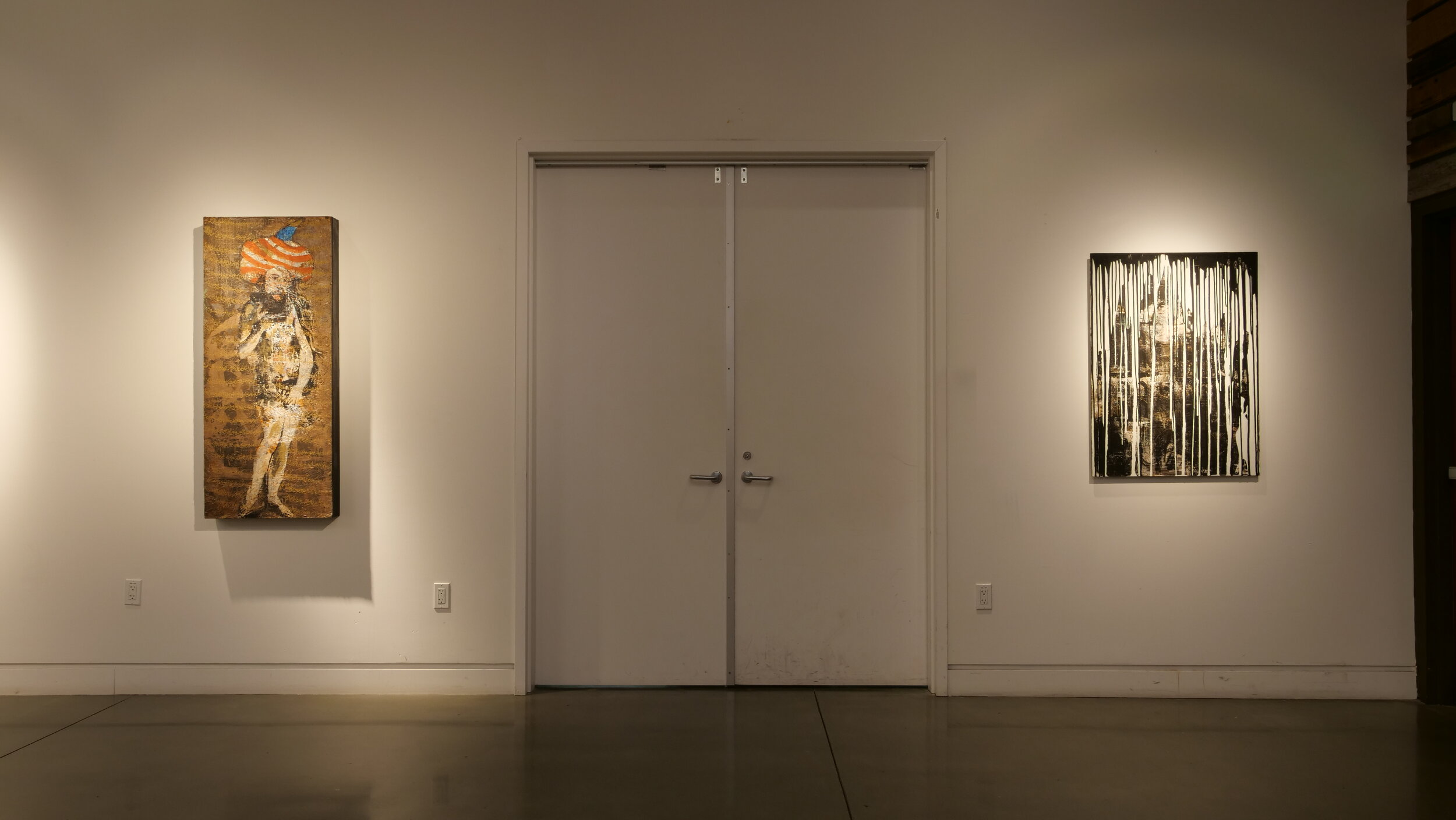 Moderately sized, warm-tone paintings hang on either side of double doors. (Copy)