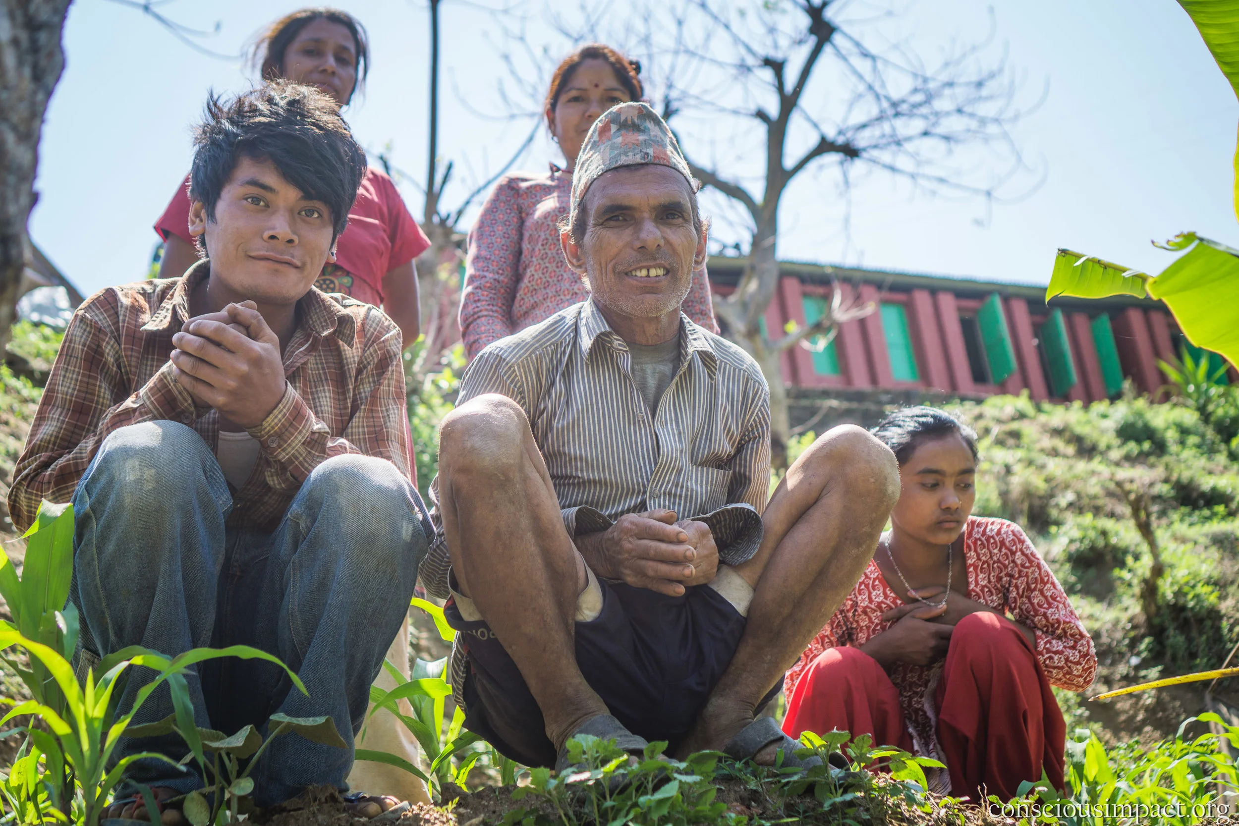 Farmers sit in front of the Bimire School as we plant our first coffee tree!