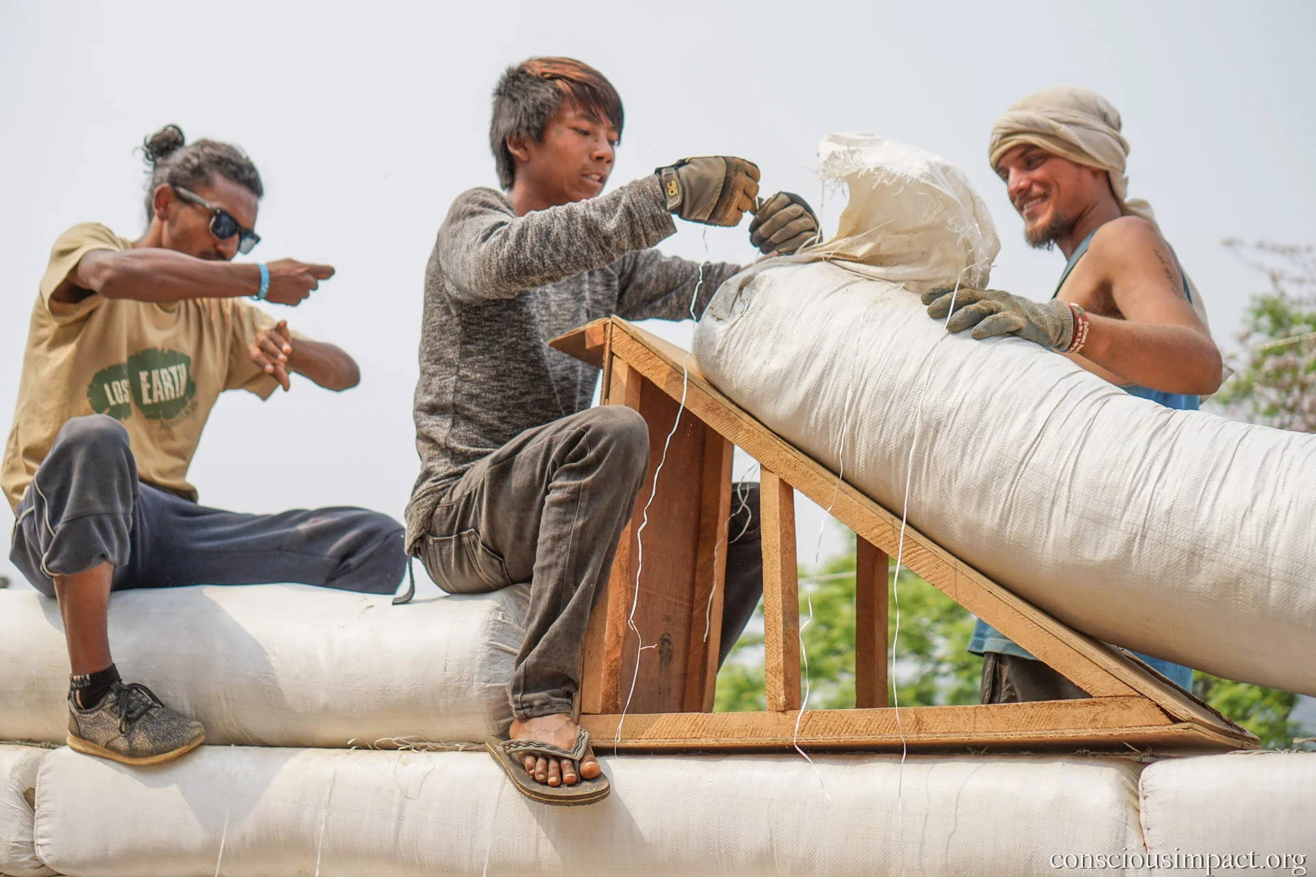 The Conscious Impact construction team, alongside local community members, build a home for a family in need in rural Nepal. Photo by Jonathan H. Lee