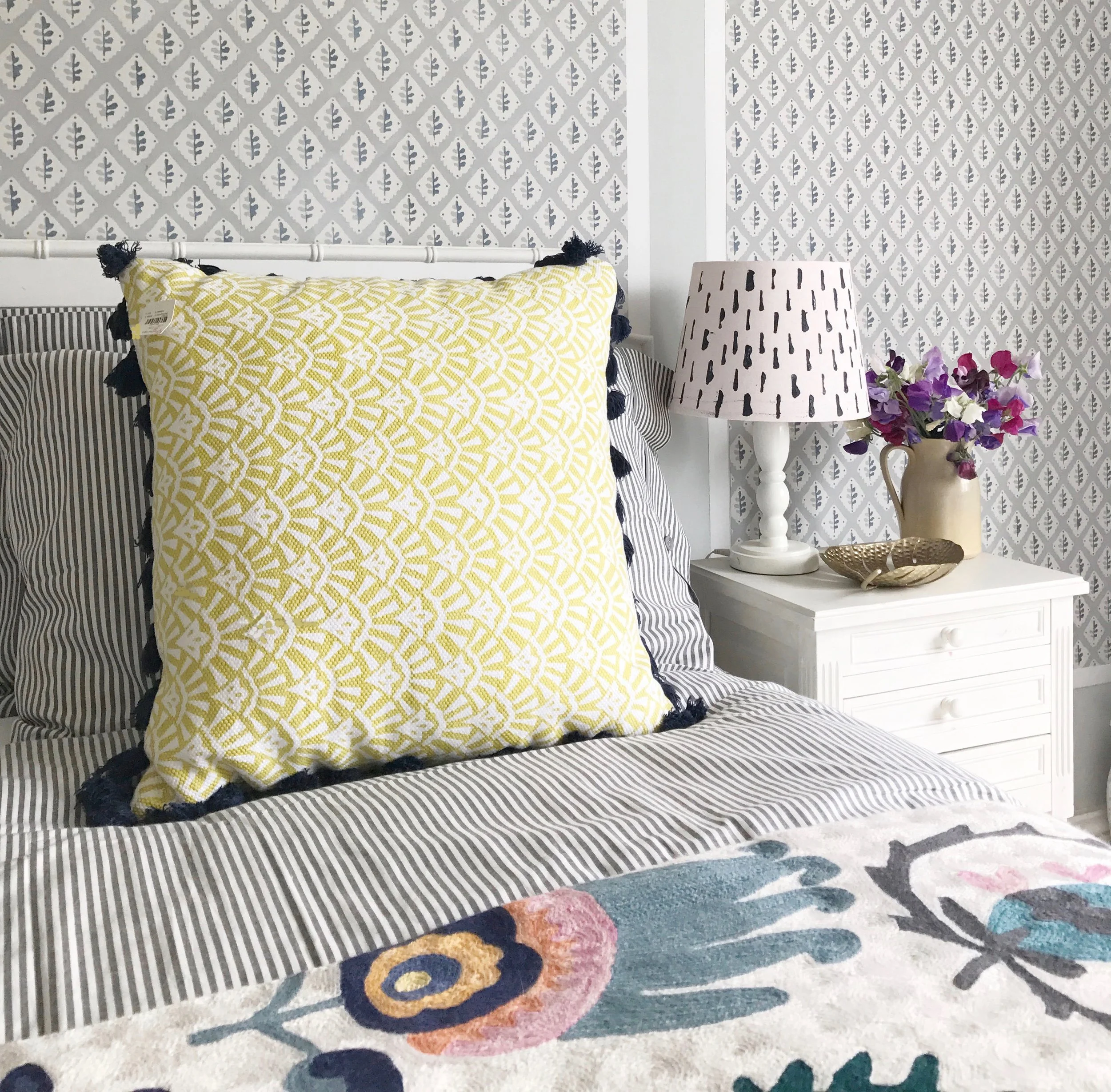 Ideas for adding colour to a light grey bedroom, add in pops of yellow and pink in your accessories with added pattern. 