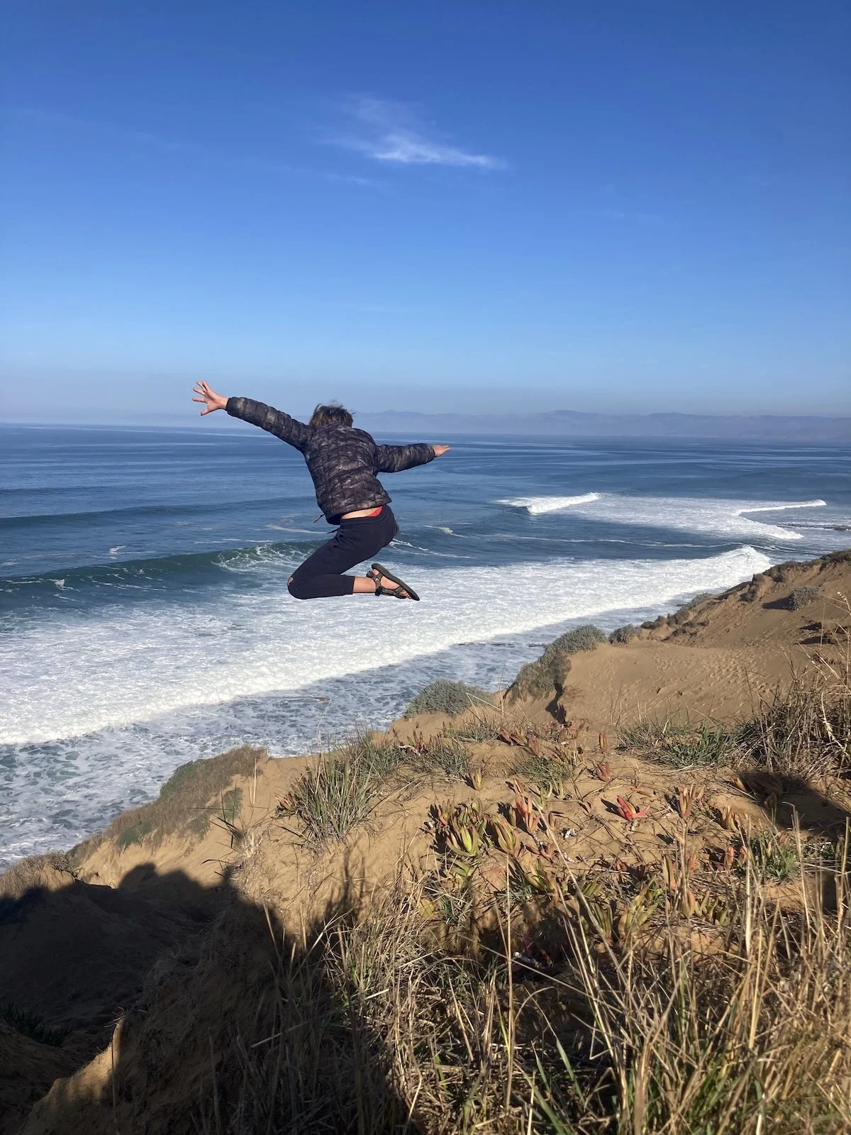 NE Jumping off sand dune at the ocean.jpeg