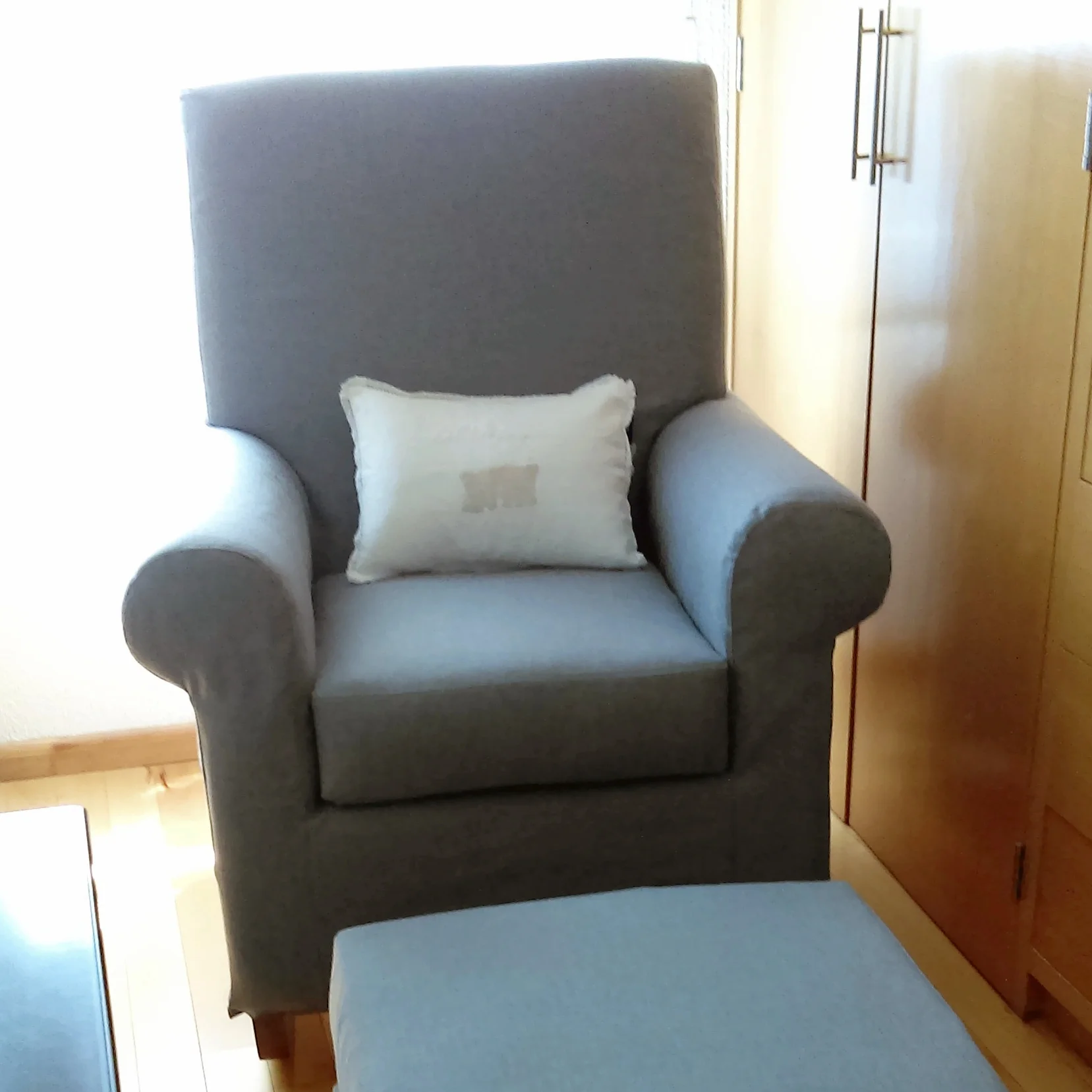 Mecedora y taburete tela gris con patas de madera de Nogal. 