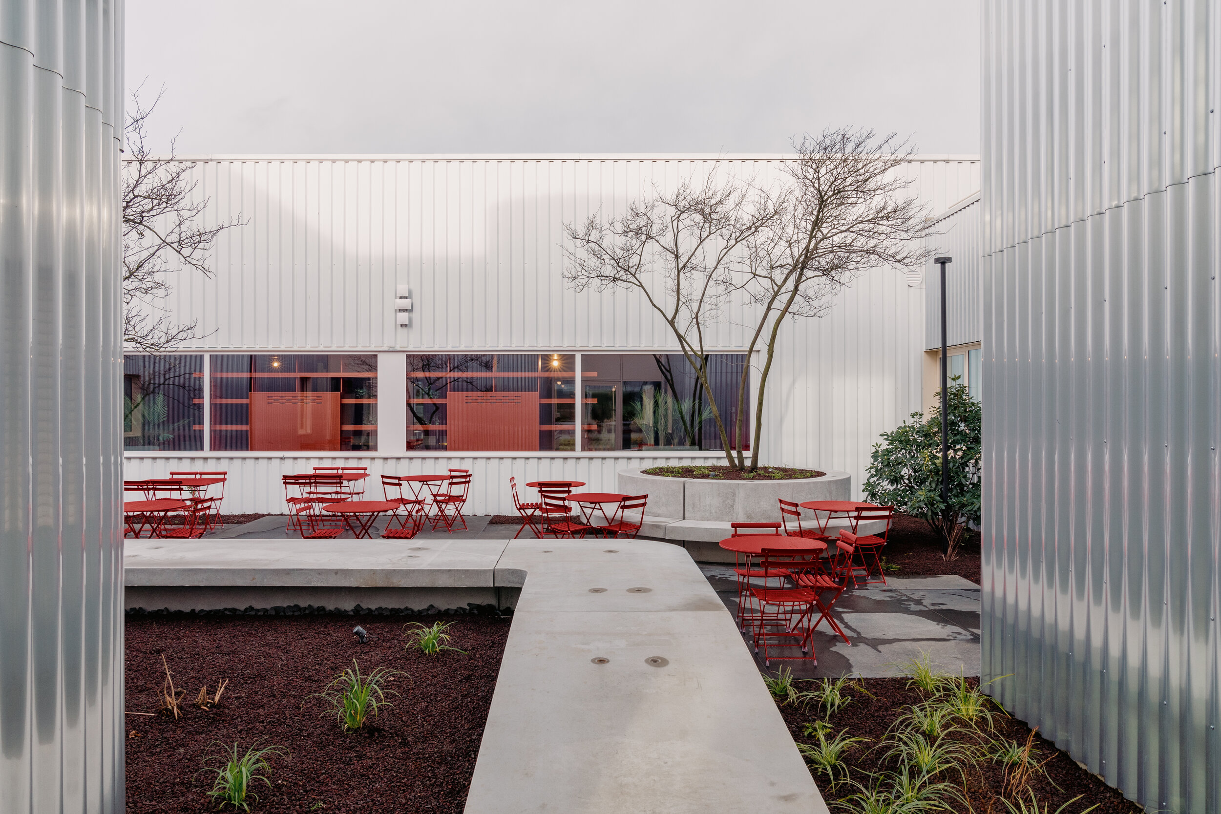  A colourful wild garden that builds upon the interior design codes embraces all of this while complementing the aluminium facade. Developed in collaboration with Van Dyck Tuinarchitectuur, varying heights of vegetation enfold towards the building wh