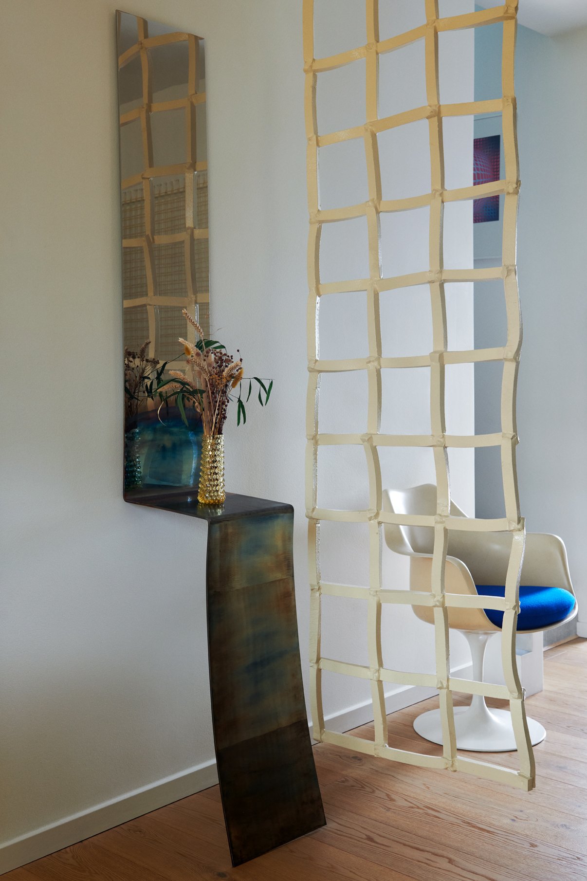  On the ground floor, separating the entryway and dining room, are two custom pieces by Denys: a mirrored console in stainless steel from the ‘Self Reflect’ series, and a ‘Foam Fence’, made from foam strips that have been rubber-coated to achieve a c