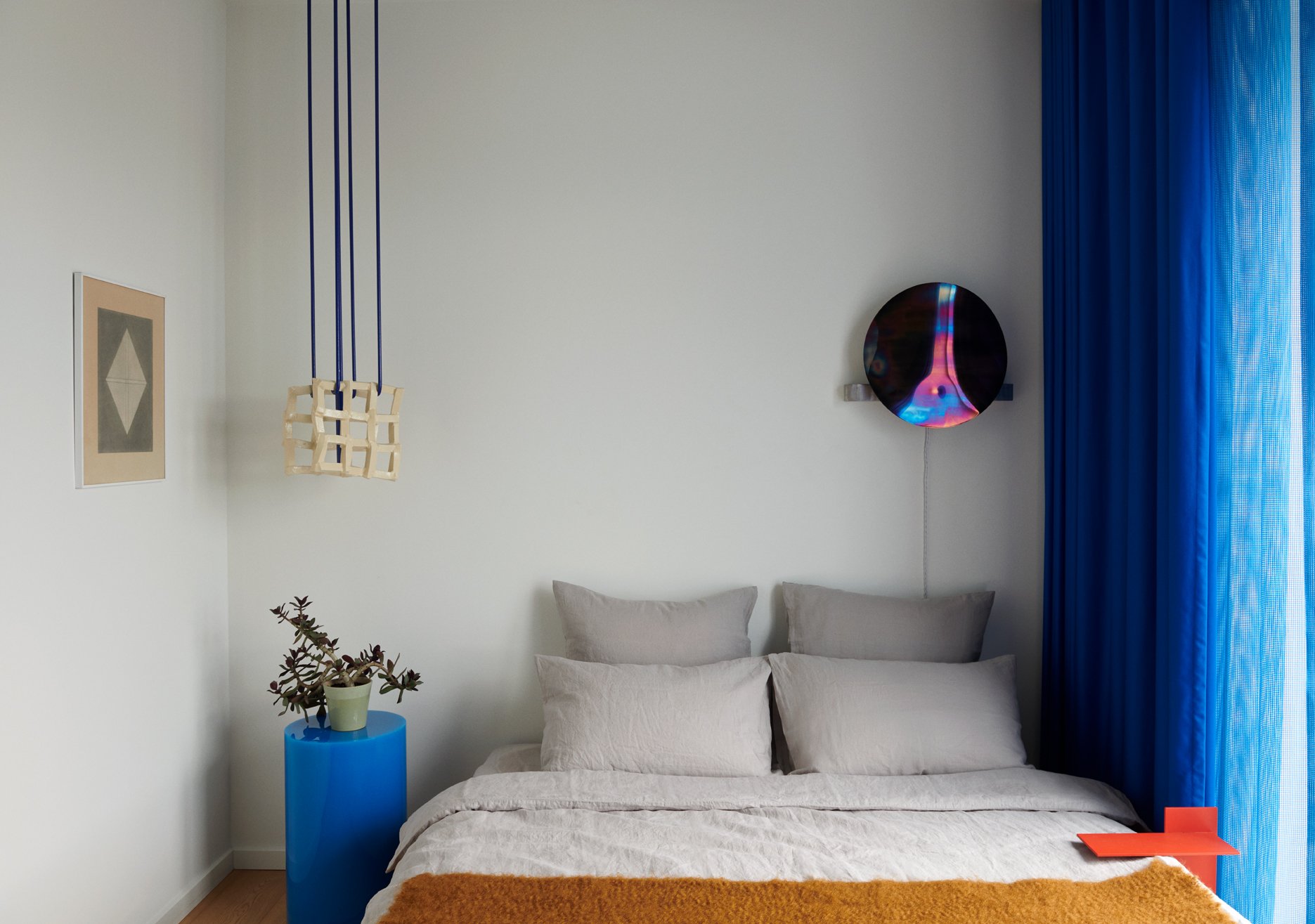  The main bedroom includes a ‘Foam Catcher’ pendant light, ‘Self Reflect’ wall sconce, and orange powder-coated-steel side table, all by Denys. A pencil drawing by Belgian artist Dan van Severen overlooks a ‘Candy Column’ side table by Sabine Marceli