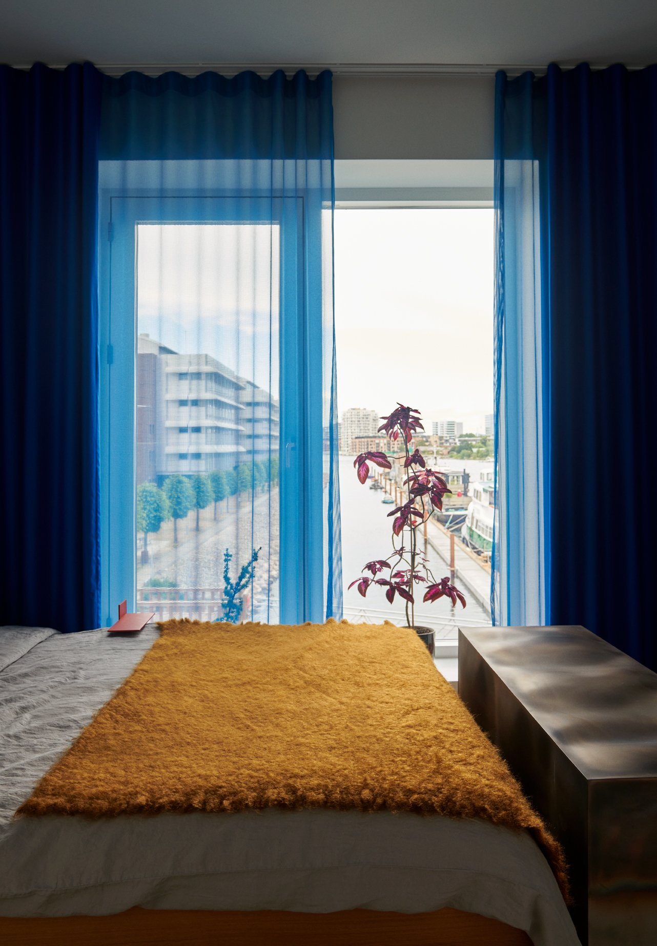  A view of Sydhavn’s houseboats from the master bedroom, which contains Denys’s ‘Element 2’ bench from the ‘Self Reflect’ series, and one of Høfler’s many coleus plants 