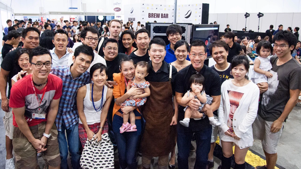 What an exhilarating way to end SNBC 2013, with Hee Wei picking up 2nd runner-up spot with his gutsy performance onstage. His cool was never fazed even when the grinder played up on him during his espresso calibration on stage. The overwhelming crowd support cheered him on through the intense 15 minutes. His months of hard work paid off in the end and we are so truly proud of his achievement.
The victory was extra sweet with the raucous cheers from Team Nylon who travelled in from all over the island to give this man their best support. (Even the little ones didn’t want to miss the fun!)
Thank you all again who made the trip and we are truly proud to be the roasters for Hee Wei. You have definitely inspired many with your passion towards the craft.
Photo credit: Grey