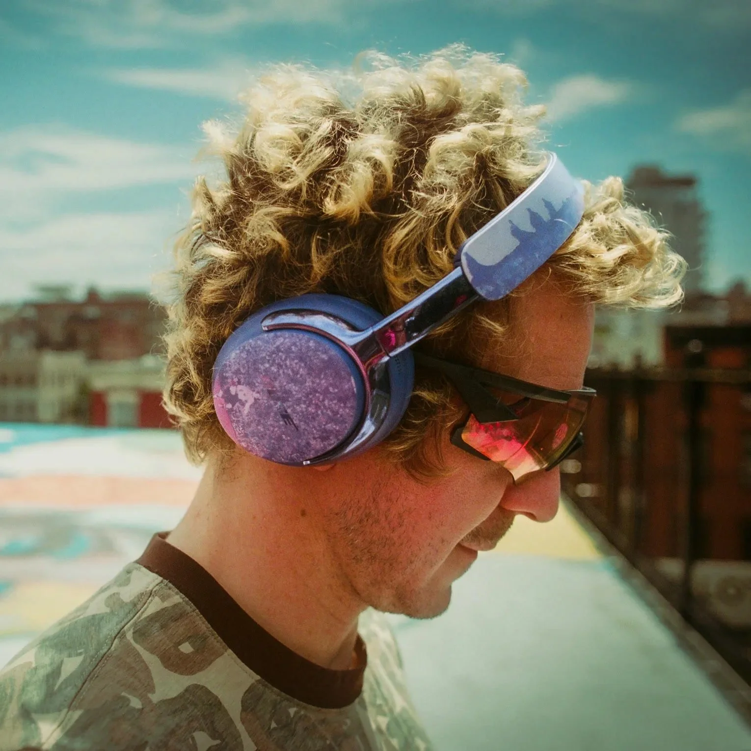 Bose x KidSuper campaign — side profile of artist wearing Midnight Violet hand-painted QuietComfort Ultra Headphones