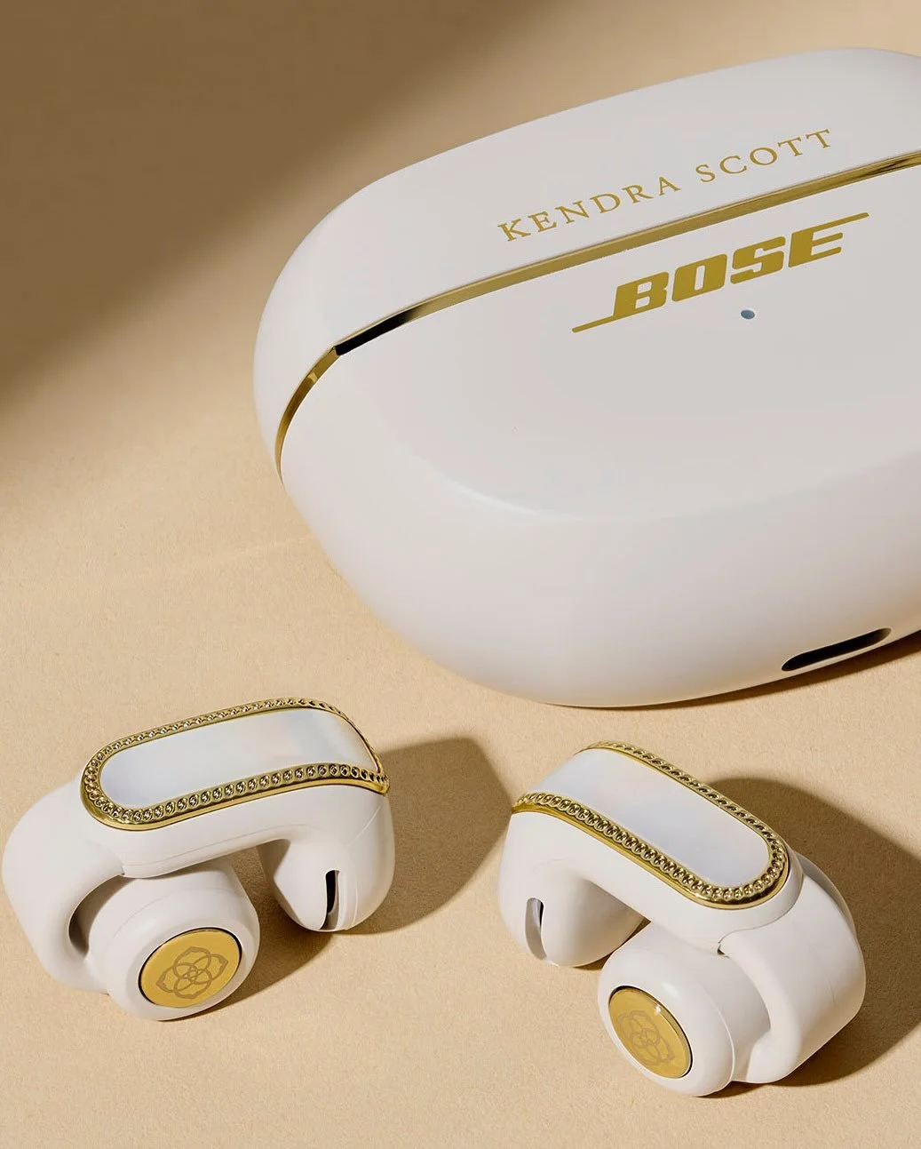 Bose x Kendra Scott Ultra Open Earbuds flat-lay with gold detailing