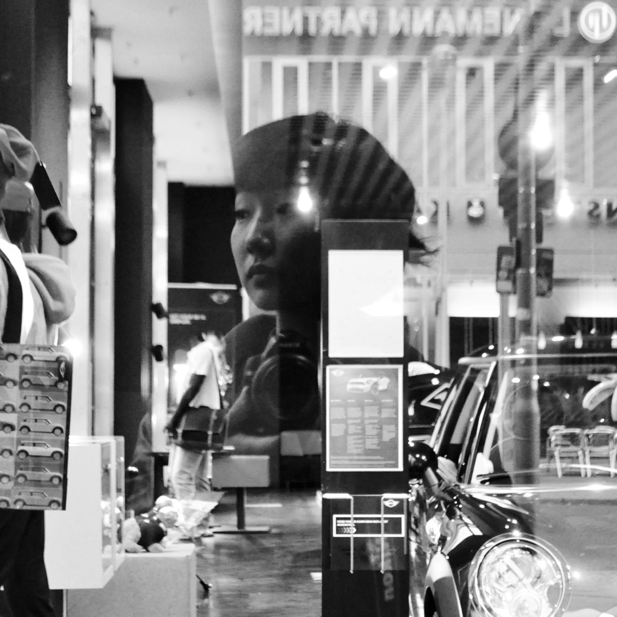 black and white self portrait of erin kim in front of a mini cooper store in berlin