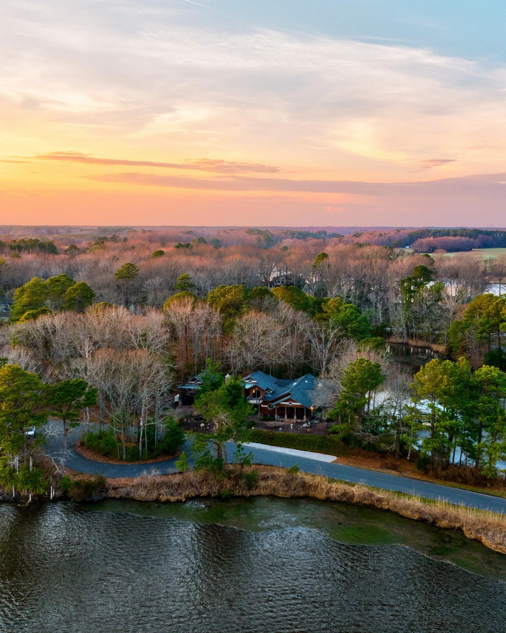 From above, it all comes into perspective.
At sunset, the home settles into its surroundings &mdash; framed by water, light, and the quiet beauty of the coast.
As twilight falls, it begins to glow &mdash; a presence that&rsquo;s both striking and ser