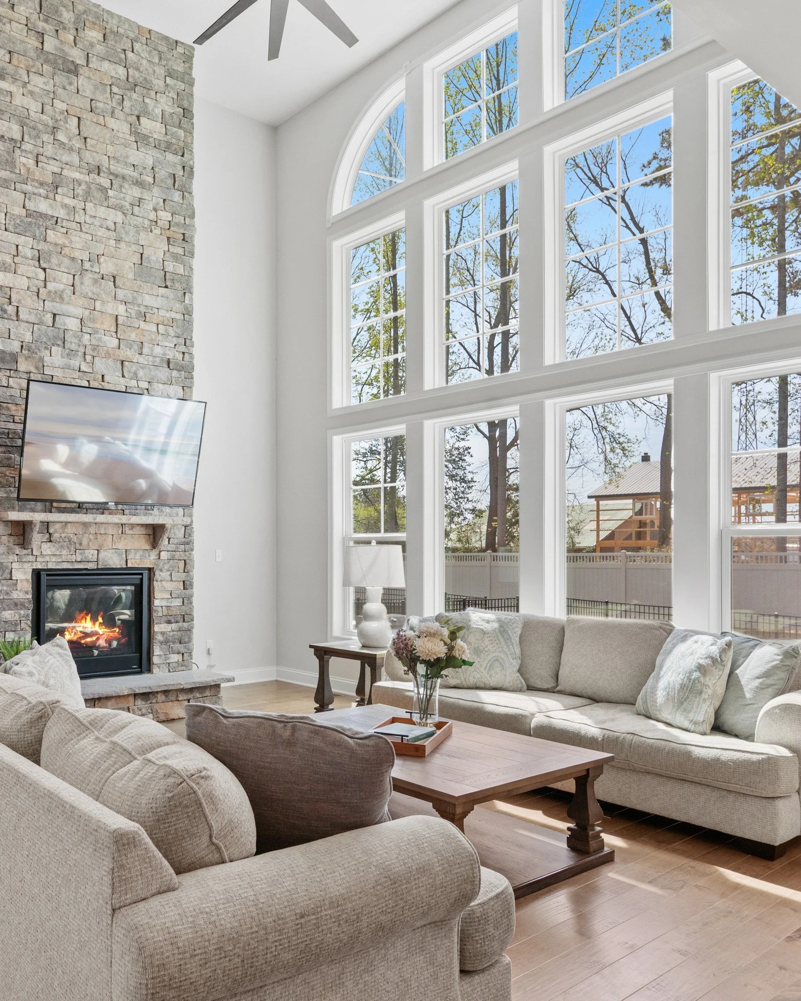 And then there&rsquo;s the living room&hellip; 
Completely wrapped in windows, overlooking a tree-filled backyard that feels like its own private escape. The light in here is unreal.
Anchored by a tall stone fireplace that draws your eye all the way 